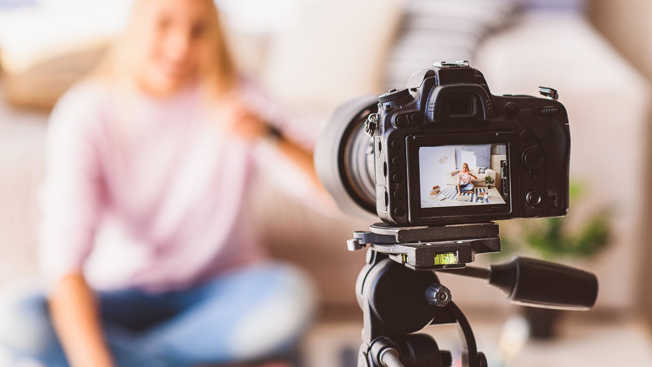 Image of camera in focus videoing girl in background